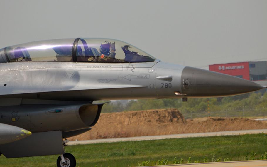An F-16 pilot gives a friendly signal as he taxis his aircraft down the flight line in preparation for his takeoff at Osan Air Base, South Korea, on May 7, 2014. The pilot is with the 36th Fighter Squadron.