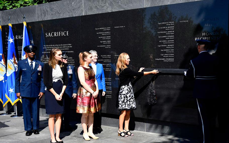 Valerie Nessel, spouse of U.S. Air Force Tech. Sgt. John Chapman, Brianna and Madison Chapman, daughters of Chapman, Secretary of the Air Force Heather Wilson, Air Force Chief of Staff Gen. David L. Goldfein and Chief Master Sgt. of the Air Force Kaleth O. Wright unveil the combat controller's name on the Air Force Memorial during a ceremony in Arlington, Va. on Aug. 24, 2018.