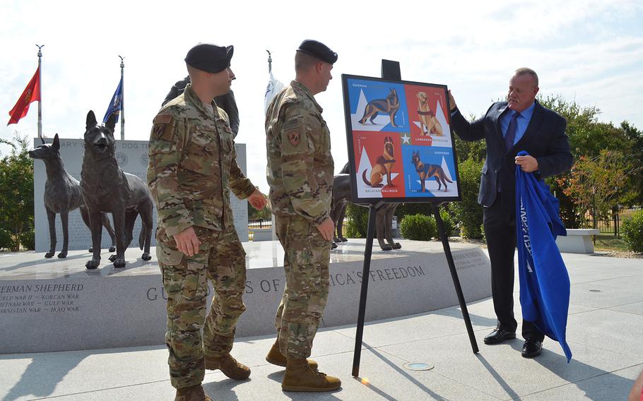 Robert Carr, San Antonio postmaster, unveils the military working dog forever stamp with Maj. Matt Kowalski and Master Sgt. Steve Kaun, both of the 341st Training Squadron, during a ceremony Thursday at military working dog memorial at Joint Base San Antonio. The new stamps are sold in sheets of 20 and honor the service of dogs in the military.