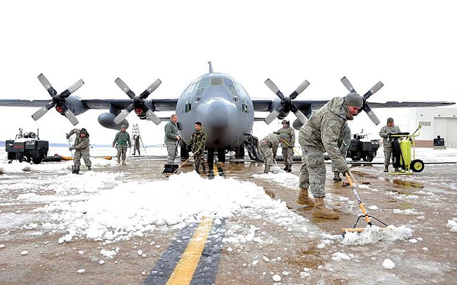 Members of the 19th Aircraft Maintenance Squadron shovel snow and ice away from a C-130 Hercules Jan. 10, 2011, on the flightline at Little Rock Air Force Base, Ark.