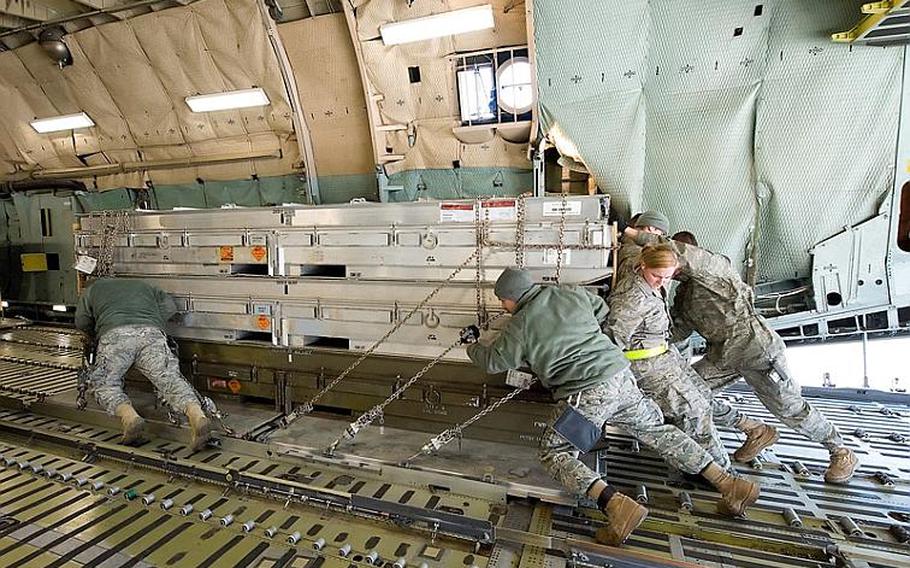 Airmen load cargo onto a C-5M Super Galaxy aircraft March 25, 2011, at Dover Air Force Base, Del. The cargo is bound for Italy in support of Operation Odyssey Dawn.