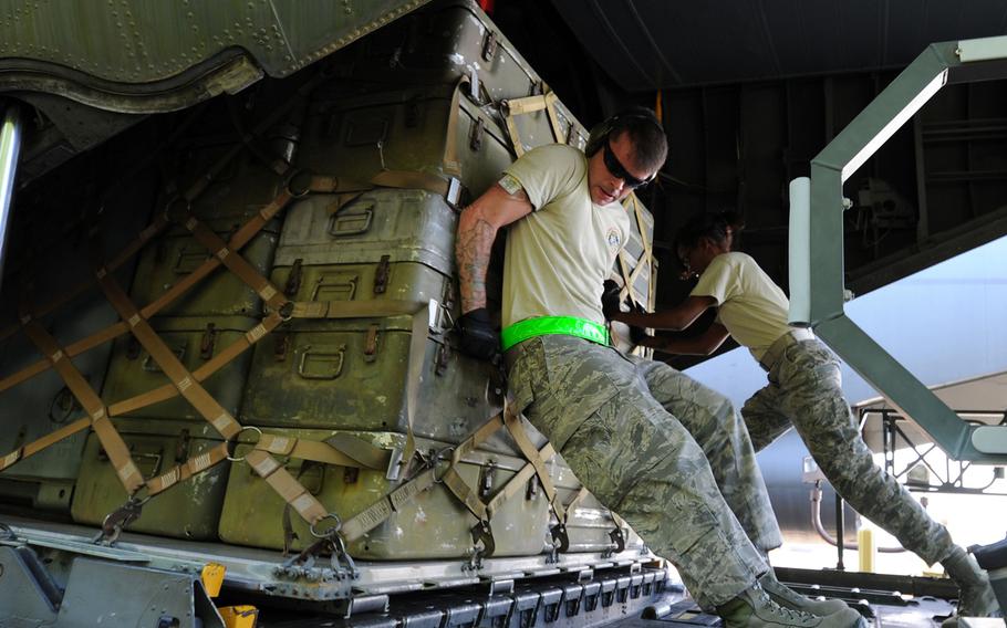 U.S. Air Force Tech Sgt. Steven Digby, left, and Senior Airman Ashanti Lane, assigned to the 71st Aerial Port Squadron, push a pallet onto a C-130 Hercules aircraft during the 25K Halverson driving and loading course at the Port Dawg Challenge, Dobbins Air Reserve Base, Ga., on June 16, 2015.