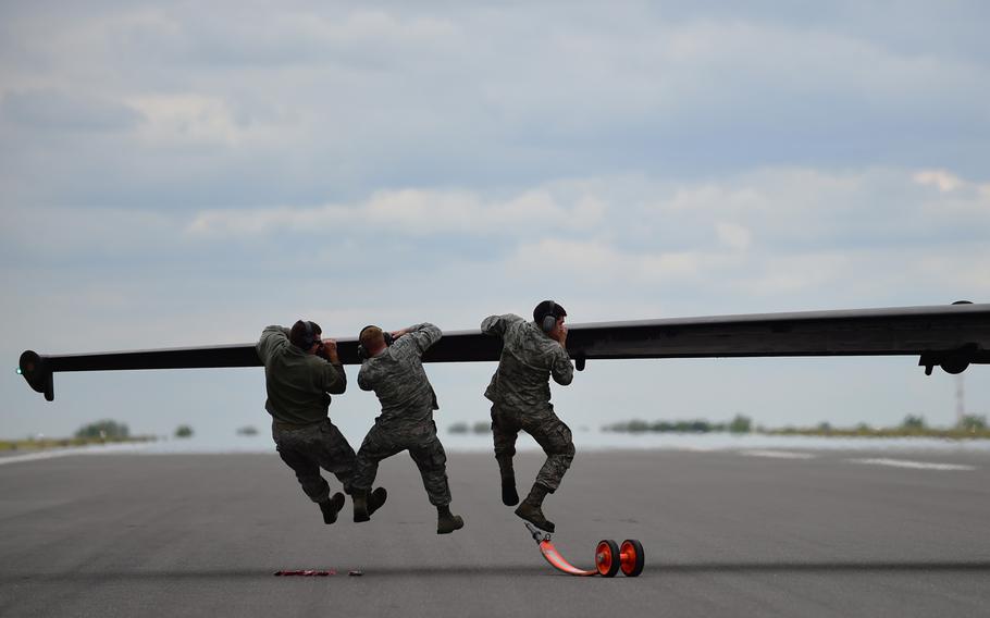 U.S. airmen push down on the wing of a U-2 Dragon Lady after its landing at RAF Fairford, United Kingdom, on Tuesday, June 9, 2015. If the aircraft lands slightly off balance, it has the potential to tilt to one side or another.