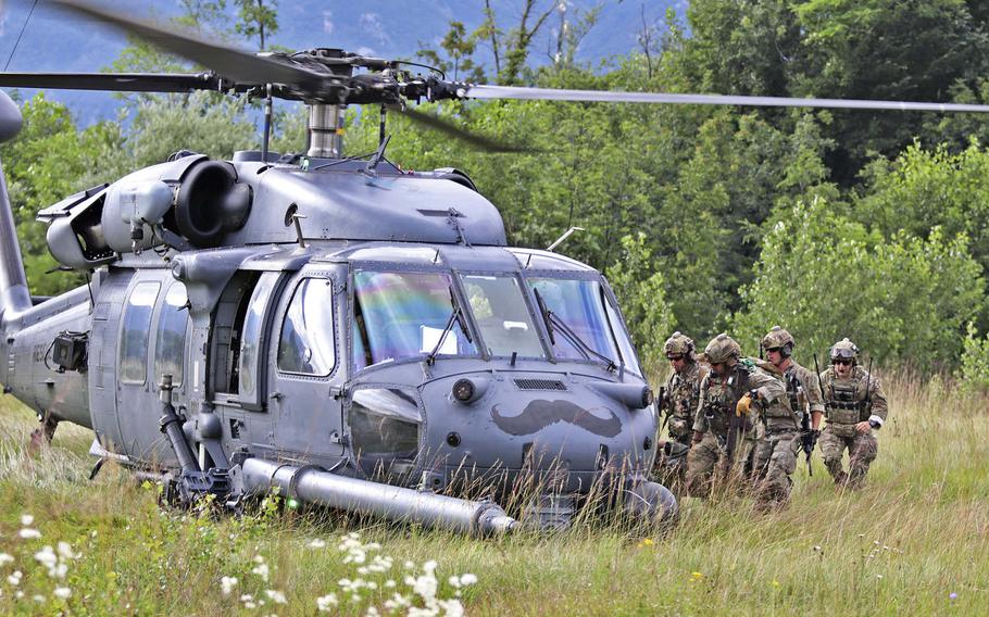 Pararescuemen with the 57th Rescue Squadron, Aviano Air Base, Italy, load a rescued downed pilot into their HH-60 Pave Hawk helicopter as part of a drill during Operation Porcupine, held at an Italian army training area located in the town of Osoppo, June 30, 2020.