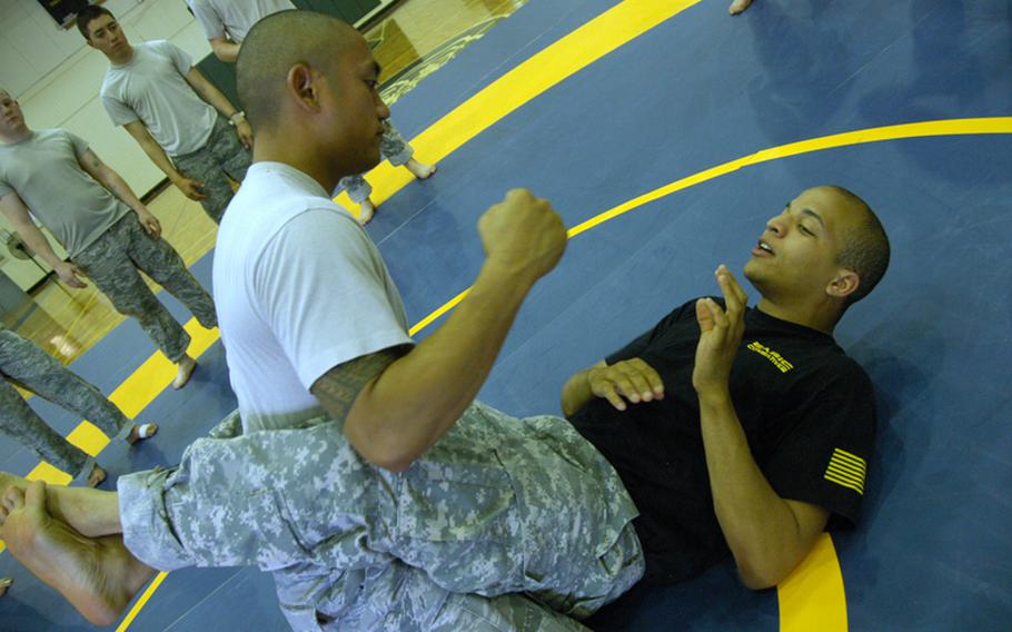 Air Force Tech Sgt. Jordan Acosta, 29, of Wahiawa, Hawaii (top) tussles with Combatives instructor Army Sgt. Matthew Prout, 26, of Baltimore at Yokota Air Base on June 24.