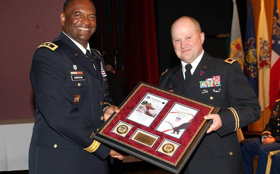 U.S. Army Japan Commander Maj. Gen. Michael T. Harrison, left, awarded U.S. Army Garrison Japan Commander Col. Eric D. Tilley with his transitioning tattoo honors at Camp Zama, June 7, 2013.