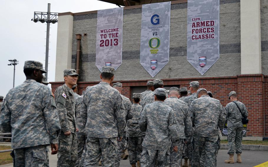 U.S. servicemembers wait to enter the Camp Humphreys Community Fitness Center in South Korea to watch the NCAA season-opening 2013 Armed Forces Classic on Saturday, Nov. 9, 2013. Oregon beat Georgetown 82-75. The televised game was part of ESPN's Veterans Week, meant to honor the U.S. military.