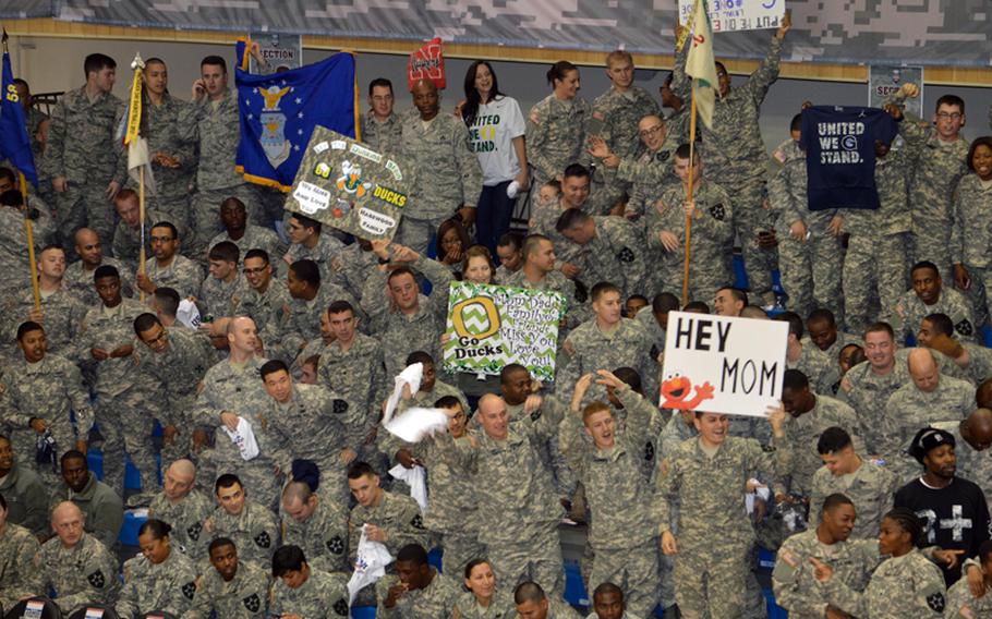 U.S. servicemembers cheer and wave signs during the 2013 Armed Forces Classic basketball game, held at the Camp Humphreys Community Fitness Center in South Korea on Saturday, Nov. 9, 2013. Oregon went on to beat Georgetown 82-75. The televised game was part of ESPN's Veterans Week, meant to honor the U.S. military.