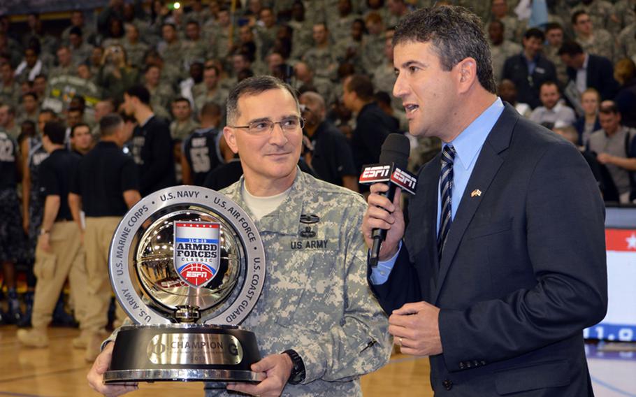 Gen. Curtis M. Scaparrotti, United Nations Command, Combined Forces Command and U.S. Forces Korea commander, presents the 2013 Armed Forces Classic basketball trophy to Oregon at Camp Humphreys, South Korea, on Saturday, Nov. 9, 2013. Oregon beat Georgetown 82-75.