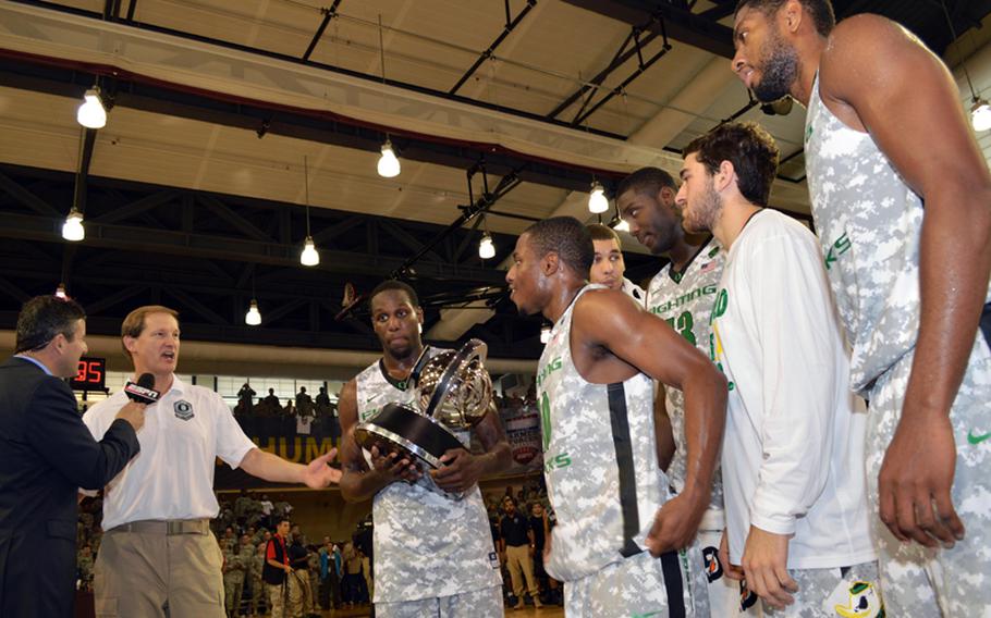 Oregon is presented with the 2013 Armed Forces Classic basketball trophy at Camp Humphreys, South Korea, on Saturday, Nov. 9, 2013. The Ducks beat the Georgetown Hoyas 82-75 in the NCAA season-opener.