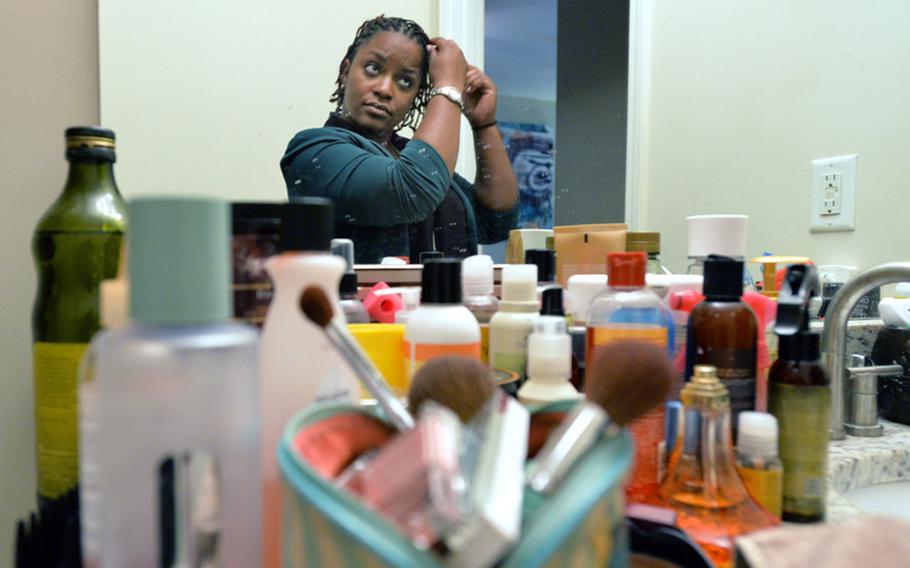 Jasmine Jacobs uses many products to do her daily hair treatment at her home in Atlanta on Tuesday, April 2, 2014. Jacobs, 6 years into what she thought was a promising and long military career, objects to a new policy that places heavy restrictions on how women can and cannot wear their hair in the military.