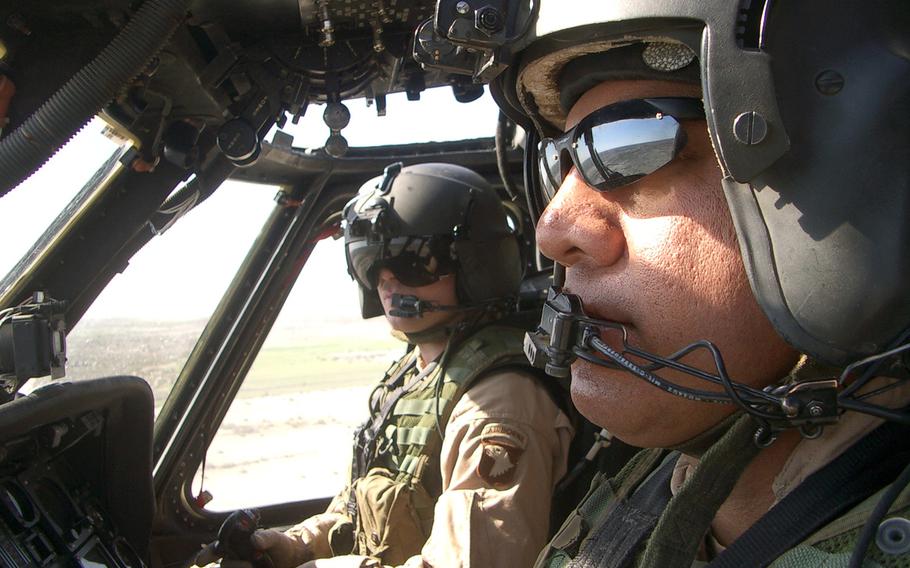 Now-retired Chief Warrant Officer 5 John Nikolao, right, in flight to Balad, Iraq, on Jan. 22, 2004. 