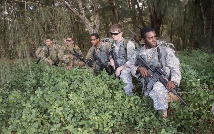 Two soldiers on the right wear the green-blue-gray Universal Camouflage Pattern during an exercise in Hawaii in 2017. 