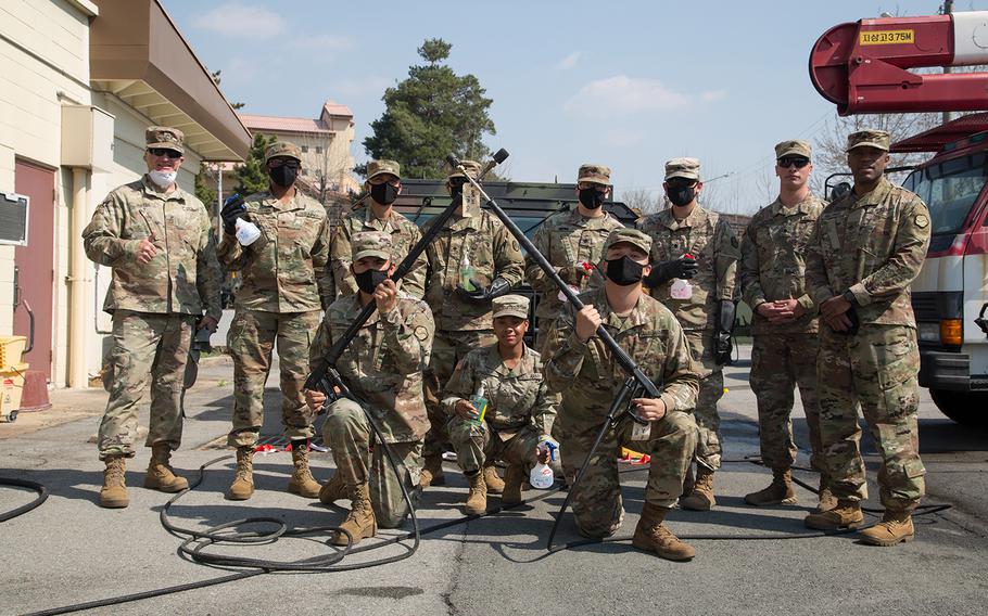 U.S. Army soldiers of the 19th Expeditionary Sustainment Command gather in front of a recently sanitized Humvee during a sanitization training event on Camp Carroll, Republic of Korea, on March 24, 2020. The soldiers participated in the sanitization training event to mitigate the spread of COVID-19.