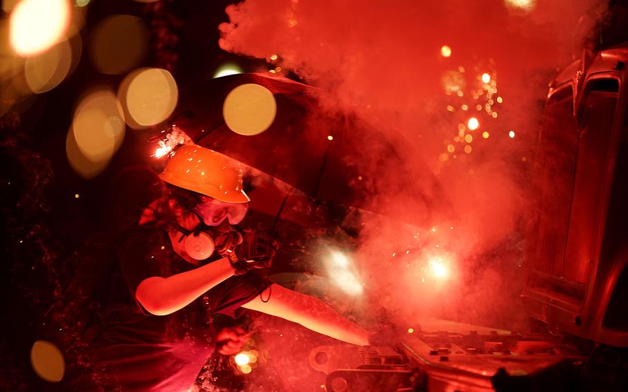 An explosive device detonates as a protester pushes back on an armored vehicle clearing the park of demonstrators during clashes outside the Kenosha County Courthouse, late Tuesday, Aug. 25, 2020, in Kenosha, Wis. 