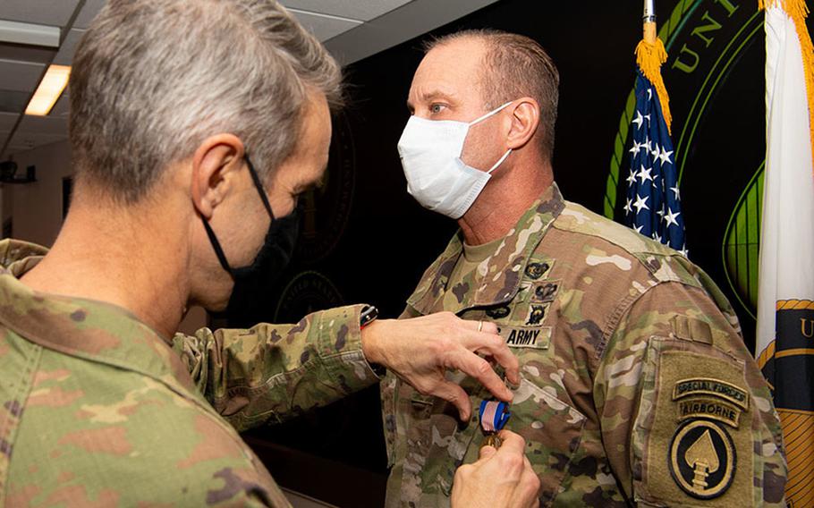 Gen. Richard D. Clarke, commander, U.S. Special Operations Command, presents Lt. Col. Larry Wyatt, USSOCOM clinic director, with a Soldier’s Medal at MacDill Air Force Base, Fla., Dec. 22, 2020. Wyatt was awarded the medal for delivering lifesaving care to two people after a motorcycle collided with bicyclists April 7, 2019, despite being injured himself. 

