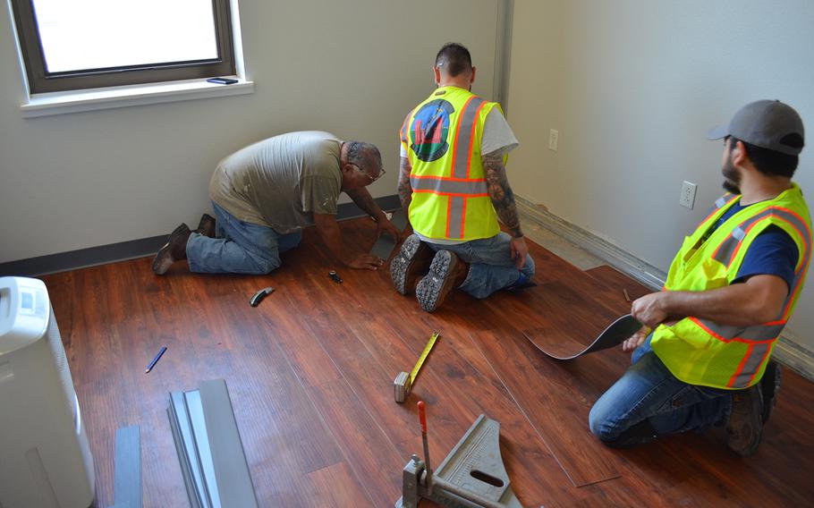 Civilian employees of the 502nd Civil Engineer Group lay new flooring Thursday in a dorm room where mold was found in building 1215 at Lackland Air Force Base in Texas. About one in six rooms at Joint Base San Antonio was found to have mold.