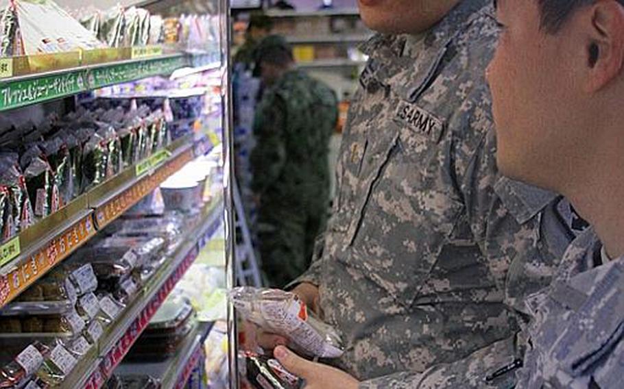 Second Lt. Matthew Meelee, left, and 2nd Lt. Travis Lee, both with the National Guard's 29th Brigade Special Troops Battalion in Hawaii, peruse the aisles of the Japanese military's version of a shoppette at Camp Kengun, Japan, on Thursday.