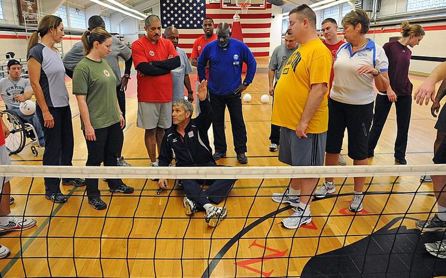 John Kessel of Team USA Volleyball, sitting, talks about the fine points of sitting volleyball. Paralympic instructors from the States led an adaptive sports clinic the week of Nov. 7, 2011, for warrior transition unit soldiers in Europe, as well as for WTU and Army morale, welfare and recreation staff, so the latter can incorporate a modified sports program at their bases for injured servicemembers and their families.