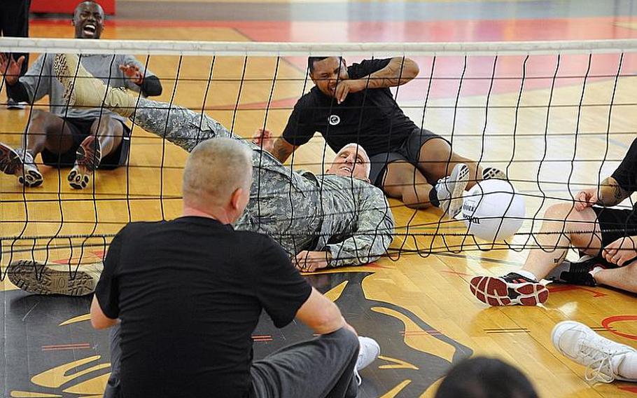United States Army Europe commander Lt. Gen. Mark Hertling watches as his shot gets caught in the net while playing sitting volleyball with Warrior Transition Unit members and staff from MWR at the Kleber gym in Kaiserslautern, Germany, on Nov. 8, 2011. Hertling was at the gym to watch a course.