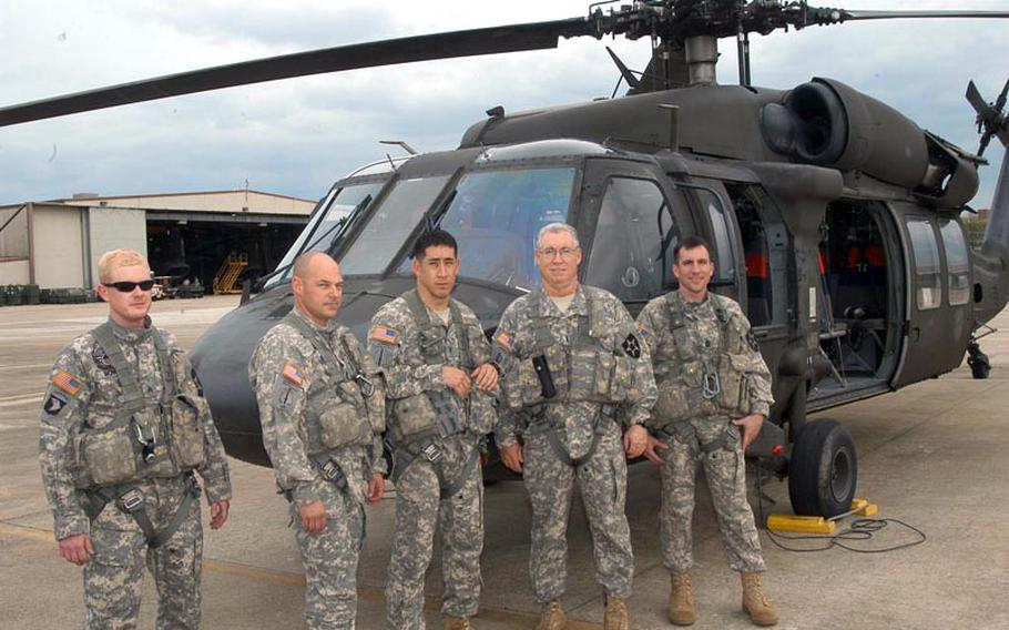U.S. Army Chief Warrant Officer 4  and pilot Dave Lilly, second from right, poses with his Black Hawk helicopter crew at Camp Humphreys in South Korea before taking off for a flight during which he would pass the personal milestone of 10,000 miles of time in the air. Joining him for the May 1, 2012, flight were, left to right, Sgt. Gary A. Mower; 1st Sgt. Jay Byrd; Mike Lilly, his son, who is a chief warrant officer 2; and 1st Sgt. Dan Schultze.