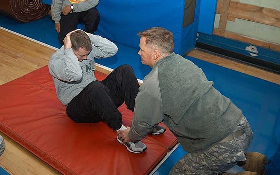Spc. Devin Sanders takes part in the sit-up portion of his unit physical fitness test on Nov. 7, 2012, at Camp Red Cloud in South Korea in advance of his planned attendance at Warrior Leader Course. The Army this month reinstituted physical fitness standards required for participation in professional military education courses.