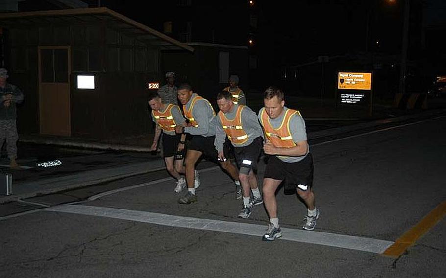 Soldiers start the two-mile run portion of their unit physical fitness test before sunrise on Nov. 7, 2012, at Camp Red Cloud in South Korea. The Army this month reinstituted physical fitness standards required for participation in professional military education courses.