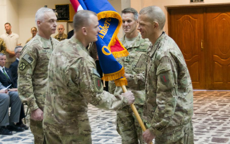 Command Sgt. Maj. Michael Grinston, right, passes the Combined Joint Forces Land Component Command-Iraq colors to Maj. Gen. Paul E. Funk II during a transfer of authority ceremony Sunday, June 28, 2015, in Baghdad.
