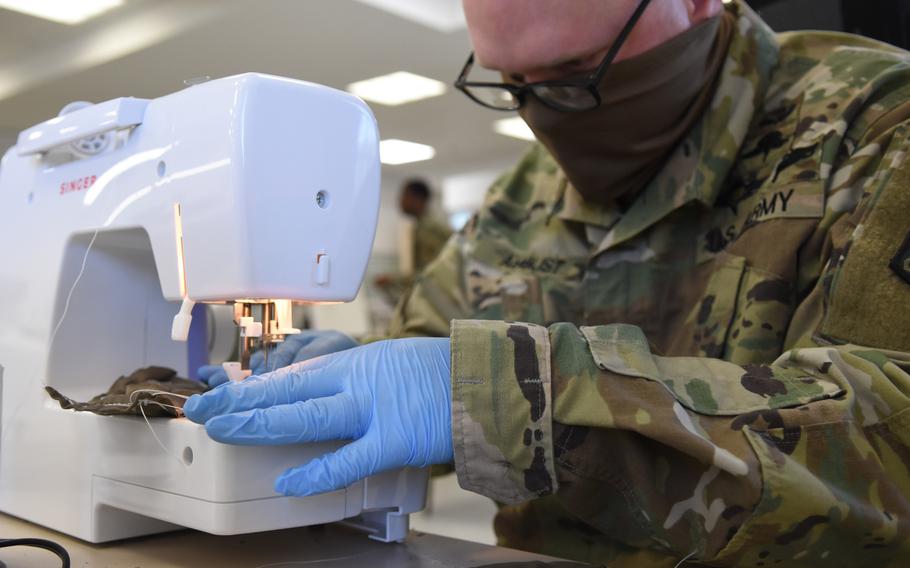 Sgt. Nicholas August, a parachute rigger with the 5th Quartermaster-Theater Aerial Delivery Company at Rhine Ordnance Barracks, Germany, a face mask together on Wednesday, April 15, 2020.