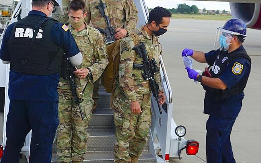 Paratroopers from the 82nd Airborne Division's 1st Brigade Combat Team confirm IDs with rosters as they pass through airfield security prior to entering Fort Bragg, N.C. They were returning from about four months in U.S. Central Command after being called up on a no-notice deployment in late December to deter Iranian aggression in the Middle East.