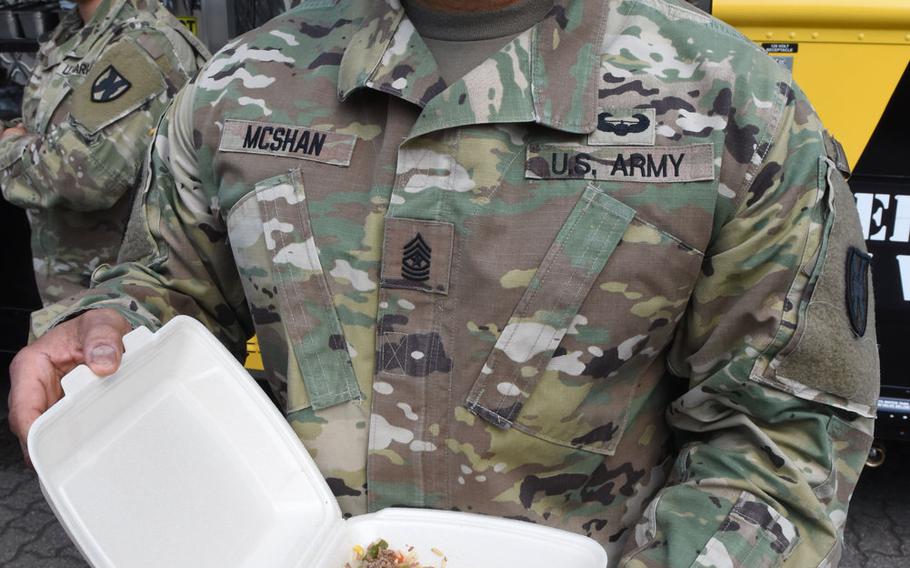 Army Sgt. Maj. Larry McShan holds up his order from the Culinary Outpost food truck on Wednesday, June 3, 2020, at Panzer Kaserne in Kaiserslautern, Germany. McShan ordered an Asian bowl with grilled teriyaki chicken and vegetables with white rice.