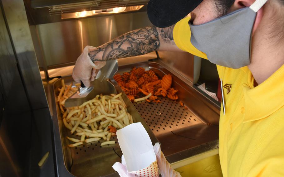 Army Sgt. Gladis Archegia, a culinary specialist with the 55th Quartermaster Company, 16th Special Troops Battalion, 16th Sustainment Brigade, scoops french fries from an air fryer in the Culinary Outpost food truck in Kaiserslautern, Germany, on Wednesday, June 3, 2020.