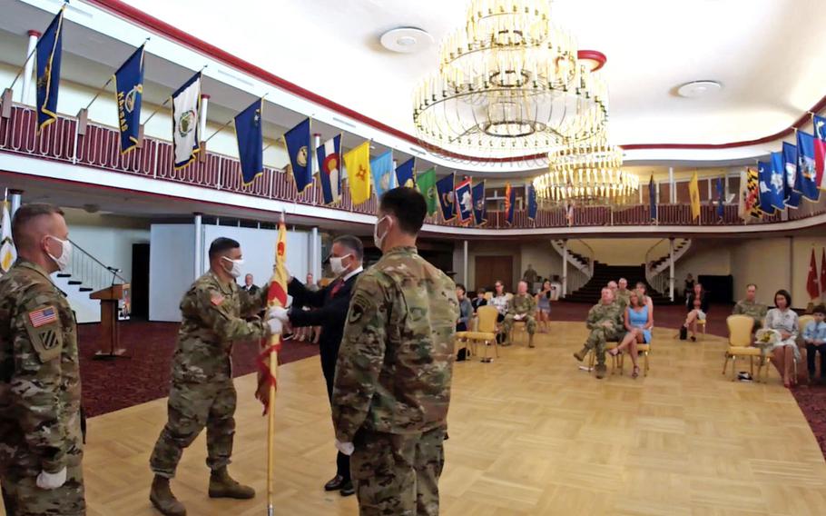 In this screenshot from the change of command ceremony in Kaiserslautern, Germany, July 22, 2020, outgoing U.S. Army Garrison Rheinland-Pfalz commander Col. Jason Edwards passes the unit's colors to Tommy Mize, director of Installation Management Command-Europe, as incoming commander Col. Vance J. Klosinski watches at right. At left is Command Sgt. Maj. Brett Waterhouse.