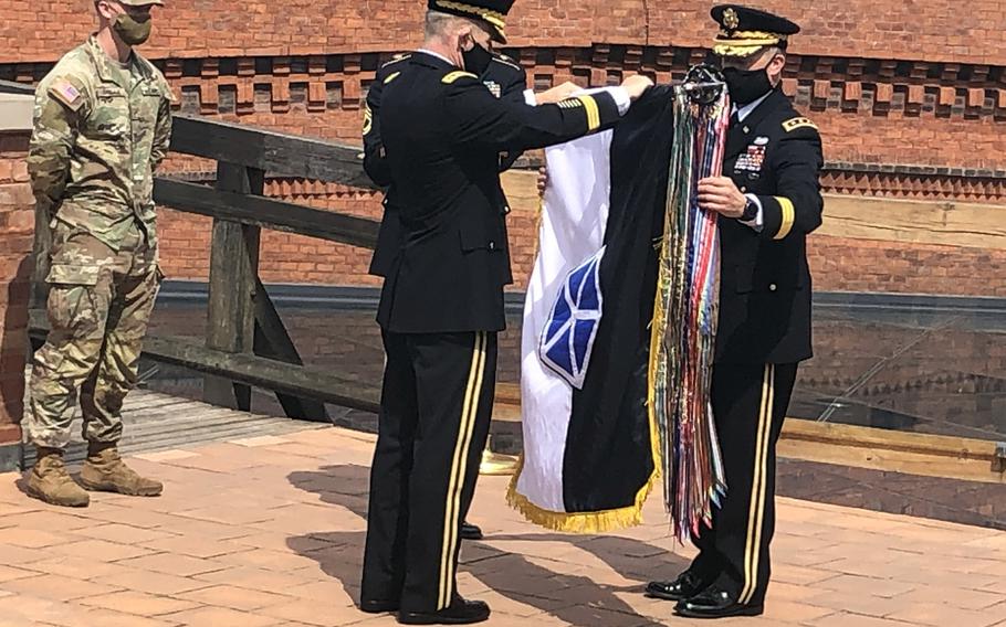 U.S. Army Chief of Staff Gen. James C. McConville and Lt. Gen. John Kolasheski, V Corps commanding general, officially unfurl the V Corps flag during a ceremony in Krakow, Poland, Aug. 4, 2020. The city of Poznan, Poland, will be the location of V Corps' forward headquarters in Europe, the Army announced Sept. 9, 2020.