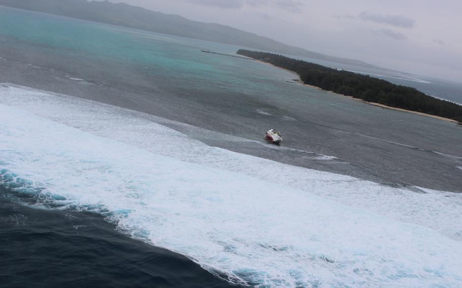 An aerial photograph of the Take Maru 55 fishing boat lying on its side by Cocos Island on Thursday. The crew of six swam to shore after being caught in the waves of a tropical storm and later picked up by the U.S. Coast Guard.