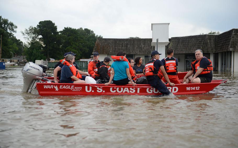 U.S. Coast Guard members rescue locals from flood water on their flat-bottom boats in Baton Rouge, Louisiana on Aug. 14, 2016.