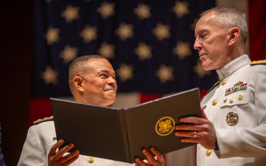 A military officer smiles at another officer while receiving an award during a ceremony in Connecticut.