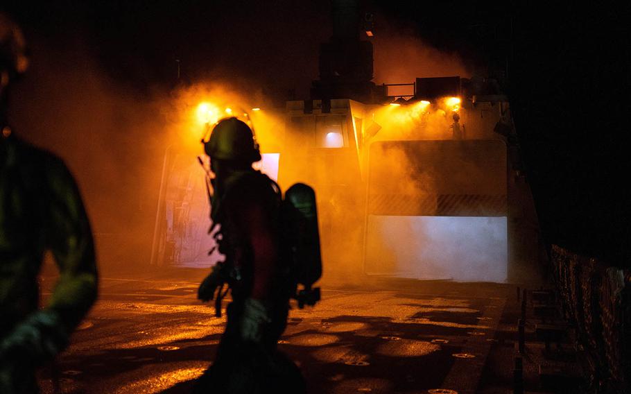 An investigator aboard the Coast Guard cutter Waesche looks back toward the superstructure after the vessel caught fire in the Pacific Ocean, Sept. 19, 2020.