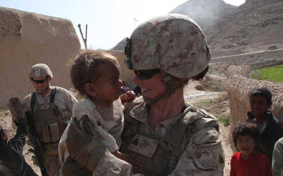 Sgt. Christina Scott, a Female Engagement Team member in direct support of 1st Battalion, 8th Marine Regiment, comforts an Afghan baby while visiting the small town of Kightewahn in the Kajaki District on March 14, 2012.