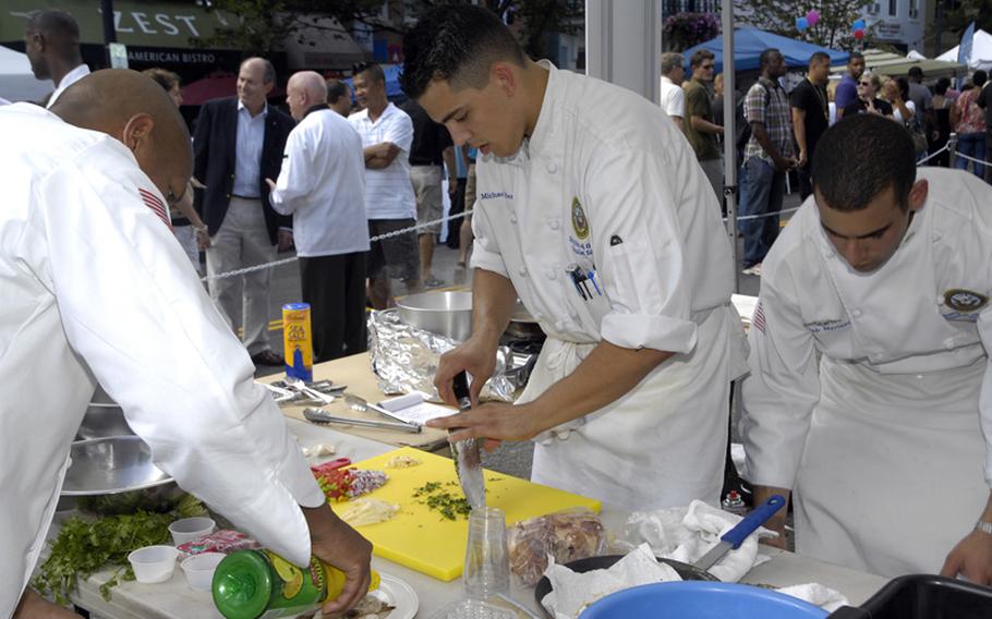 The Secretary of the Navy's Mess Team Blue prepares a meal in the final round of the 2012 Military Culinary Competition in Washington, D.C., on Saturday, Sept. 22, 2012. From left are Petty Officers 2nd Classes Dion Yipon, Michael Derry, and Joseph Mariano.