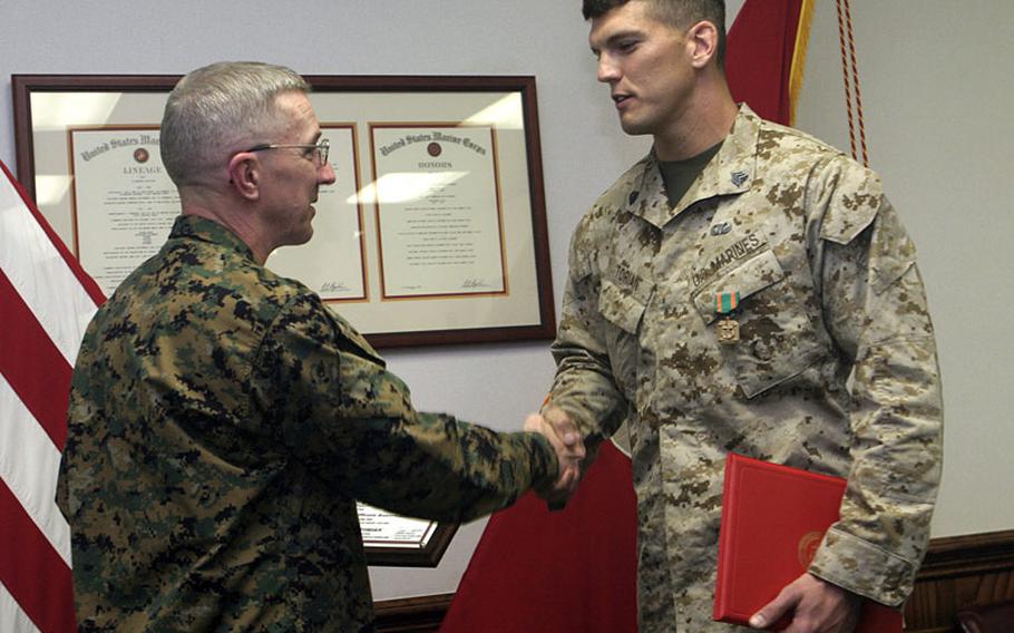 Then-Sgt. Aaron C. Torian of 2nd Reconnaissance Battalion, right, is congratuated by Maj. Gen. Richard A. Huck, 2nd Marine Division's commanding general, for being named the 2005 division NCO of the year Jan. 16, 2006, at Camp Lejeune, N.C.