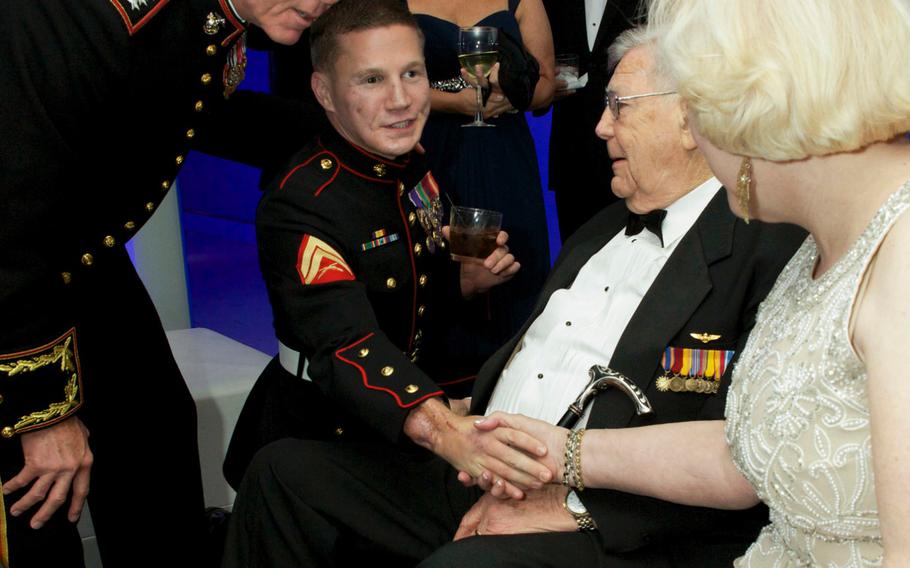 Marine Cpl. William Kyle Carpenter kneels beside Gen. James F. Amos, the 35th Commandant of the Marine Corps, while being introduced to guests at the Gaylord National Resort and Convention Center, at the National Harbor in Maryland on Nov. 9, 2013.