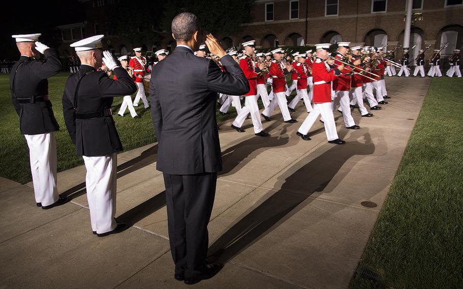 President Barack Obama, Marine Corps Commandant Gen. James Amos and Marine Corps Barracks Washington Commanding Officer Col. Christian Cabaniss salute as bands and drill teams pass in review during the evening parade at the barracks on June 27, 2014.
