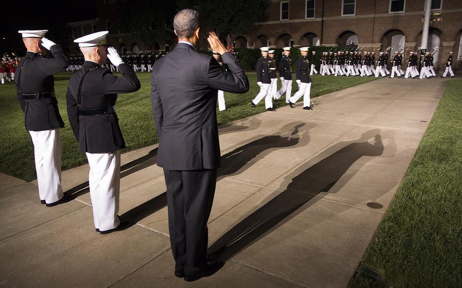President Barack Obama, Marine Corps Commandant Gen. James Amos and Marine Corps Barracks Washington Commanding Officer Col. Christian Cabaniss salute as bands and drill teams pass in review during the evening parade at the barracks on June 27, 2014.