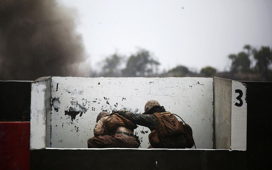 Marines duck behind a barrier after throwing a grenade at Pohakuloa Training Area, Hawaii, July 20, 2014, during Rim of the Pacific (RIMPAC) Exercise 2014. 