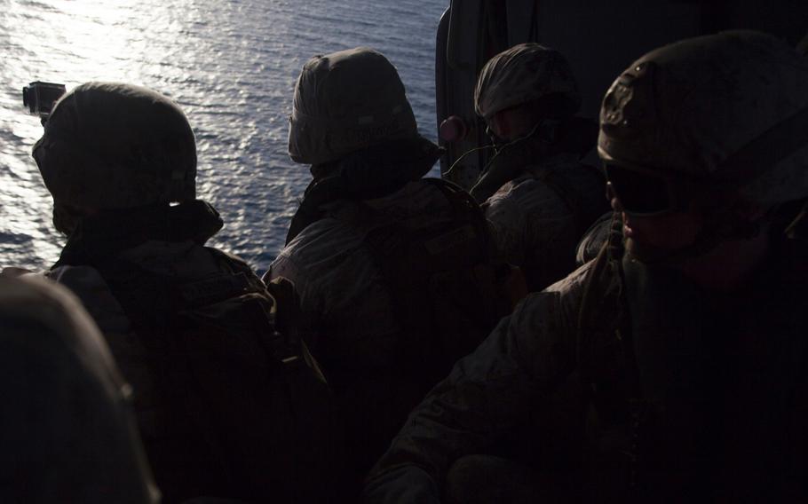 Marines with Company C, 3rd Platoon, of the Fleet Anti-Terrorism Security Team look over the Persian Gulf before fast-roping out an MH-60 Seahawk during training aboard the afloat forward staging base USS Ponce, Sept. 18, 2015. FAST trains to provide quick-reaction reinforcement of security at U.S. naval and national assets, including U.S. embassies, for a limited duration.