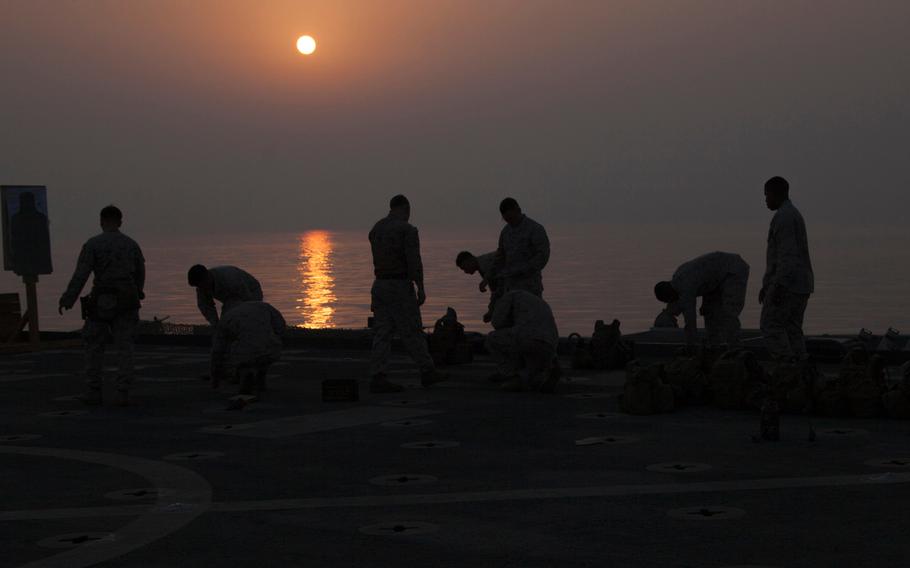 Marines with Company C, 3rd Platoon, of the Fleet Anti-Terrorism Security Team, pick up 9 mm rounds after a live-fire exercise aboard the afloat forward staging base USS Ponce, Sept. 17, 2015.