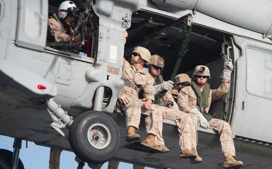 From left, Sgt. Diego Maltes, Lt. Cpl. Connor Runser and Cpl. Jake Allen, Marines with Company C, 3rd Platoon, of the Fleet Anti-Terrorism Security Team ride in an MH-60 Seahawk before fast-roping during training aboard the afloat forward staging base USS Ponce, Sept. 18, 2015. 