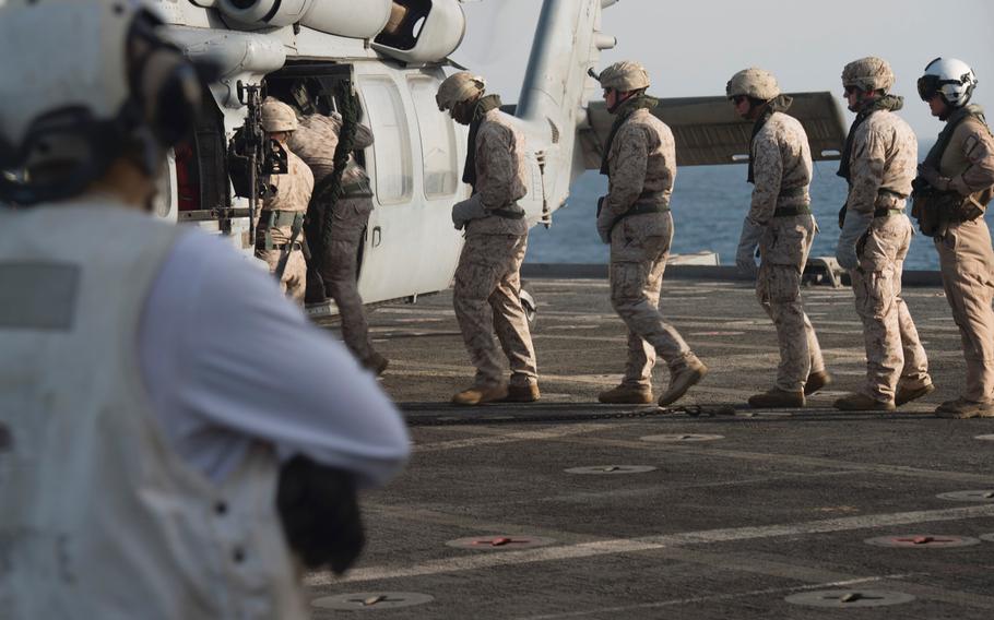 Marines with Company C, 3rd Platoon, of the Fleet Anti-Terrorism Security Team load onto an MH-60 Seahawk during fast-rope training aboard the afloat forward staging base USS Ponce, Sept. 18, 2015. FAST trains to provide quick-reaction reinforcement of security at U.S. naval and national assets, including U.S. embassies, for a limited duration. 