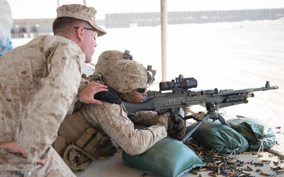 Sgt. Joseph Doberick, left, a Marine with Company C, 4th Platoon, of the Fleet Anti-Terrorism Security Team helps fellow FAST team member Lt. Cpl. Nicholas Smith during a machine gun shoot in Bahrain, Aug. 26, 2015.  FAST trains to provide quick-reaction reinforcement of security at U.S. naval and national assets.